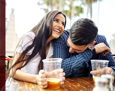 hombre y mujer riendo juntos tomando unas bebidas