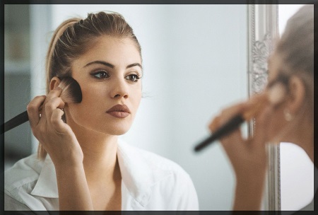 mujer arreglandose frente a un espejo